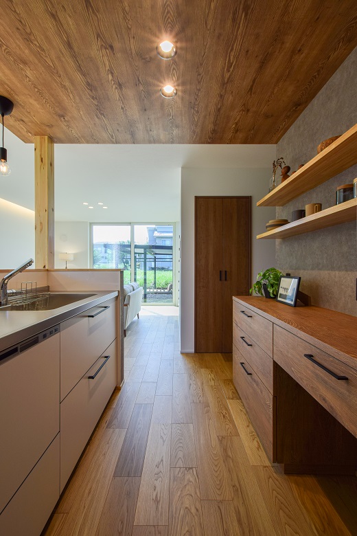 床や天井の木目色を統一した造作カップボードが印象的なキッチン空間