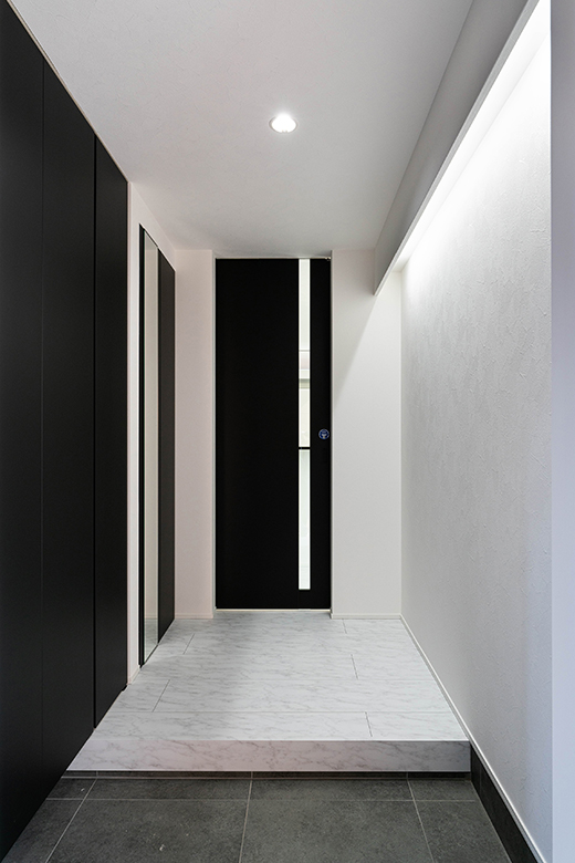 白を基調に、黒い建具でスタイリッシュにまとまった内装。間接照明の光が洗練された空間を演出する