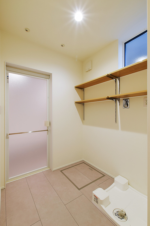 壁付けの収納棚が備えたシンプルなランドリールーム