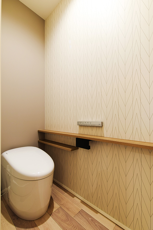 上品なヘリンボーン柄のクロスがアクセントになったトイレスペース