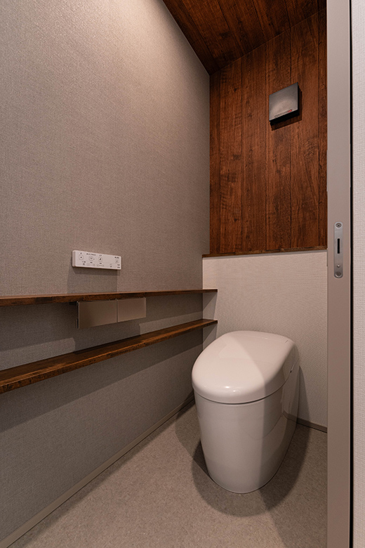 トイレは、木目調のアクセントウォールと天井が居心地の良い空間に。落ち着いた色合いと質感が調和し、上質な雰囲気を演出