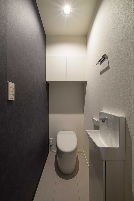 モノトーンのアクセントクロスが上品でシックな雰囲気のトイレ空間