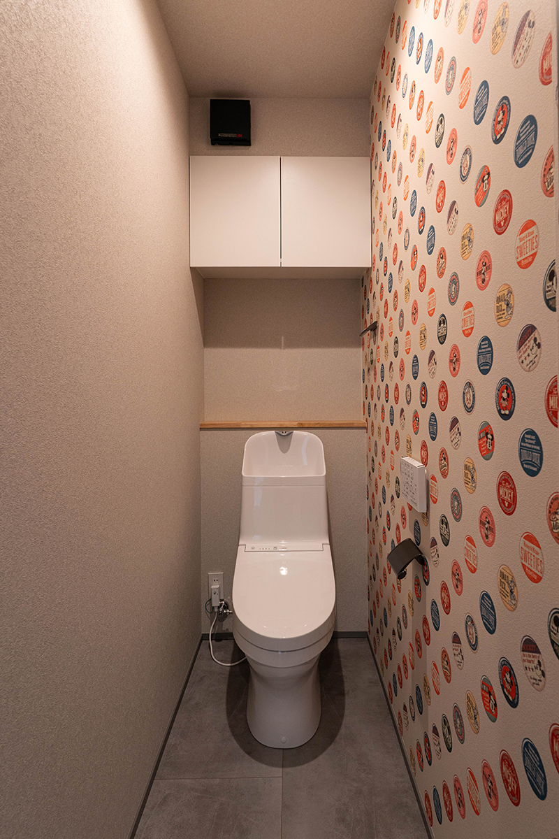 2階トイレは、 缶バッジモチーフのディズニークロスを一面に。限られたスペースの中で個性を表現し、日常にさりげない楽しさをもたらす