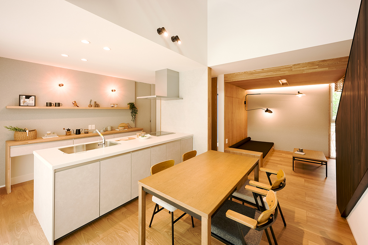間接照明が柔らかく空間を包み込む、温もりあるLDK。キッチンとダイニングがゆるやかにつながり、奥には籠もり感のあるソファスペースも