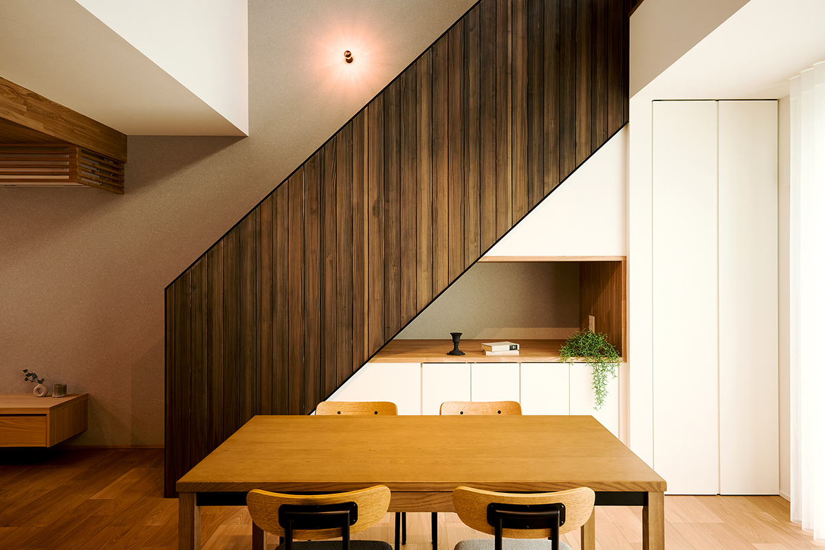 存在感のある意匠階段が空間のアクセントに。縦ラインの木材が陰影を生み、洗練された雰囲気に
