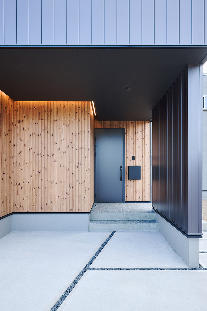 軒下に柔らかな灯りを仕込み、木の質感を引き立てた玄関アプローチ。落ち着きと温もりを感じる迎え入れの空間