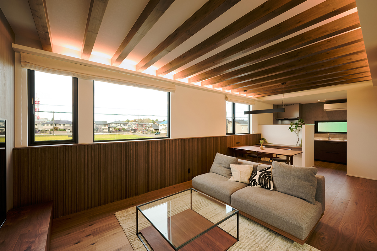 間接照明が梁を照らし出し、柔らかな光に満たされるLDK。窓の外に広がる景色が、日常のひとときを穏やかに彩る
