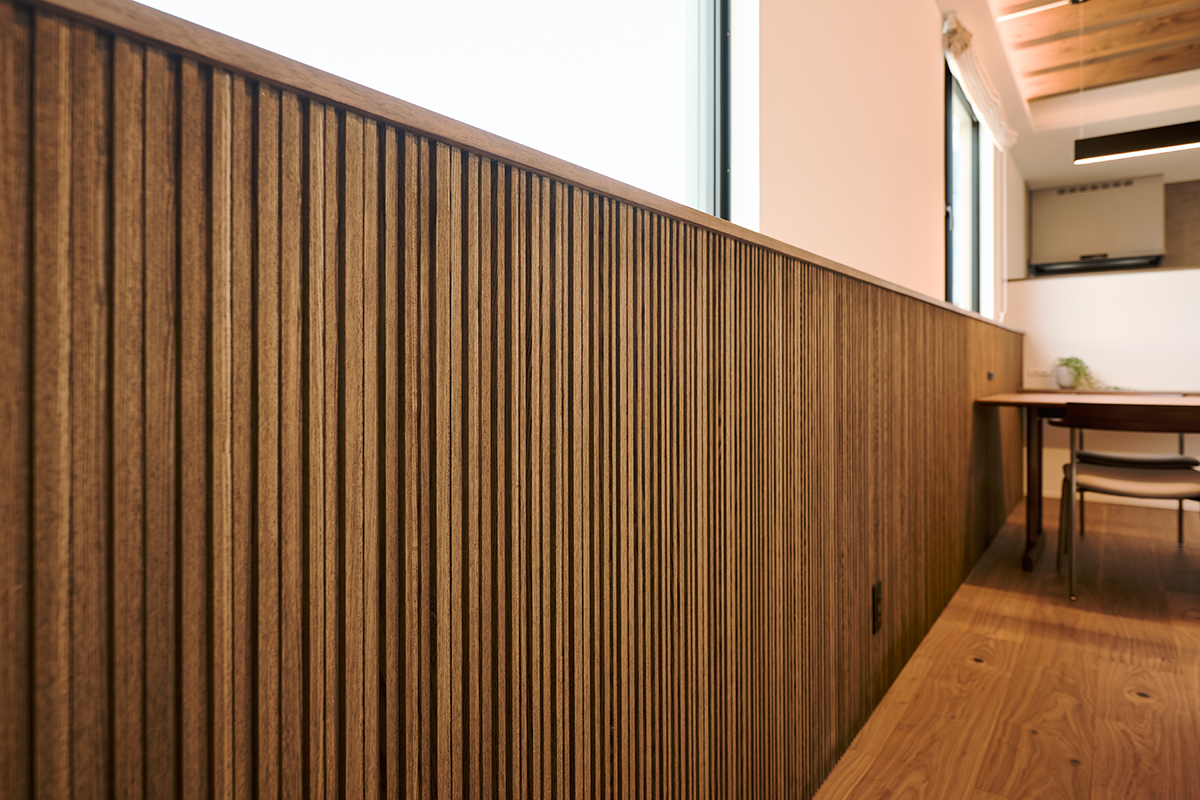 縦ラインのリブ材が空間を引き締める腰壁。素材の質感が際立ち、室内に表情を生む仕立て