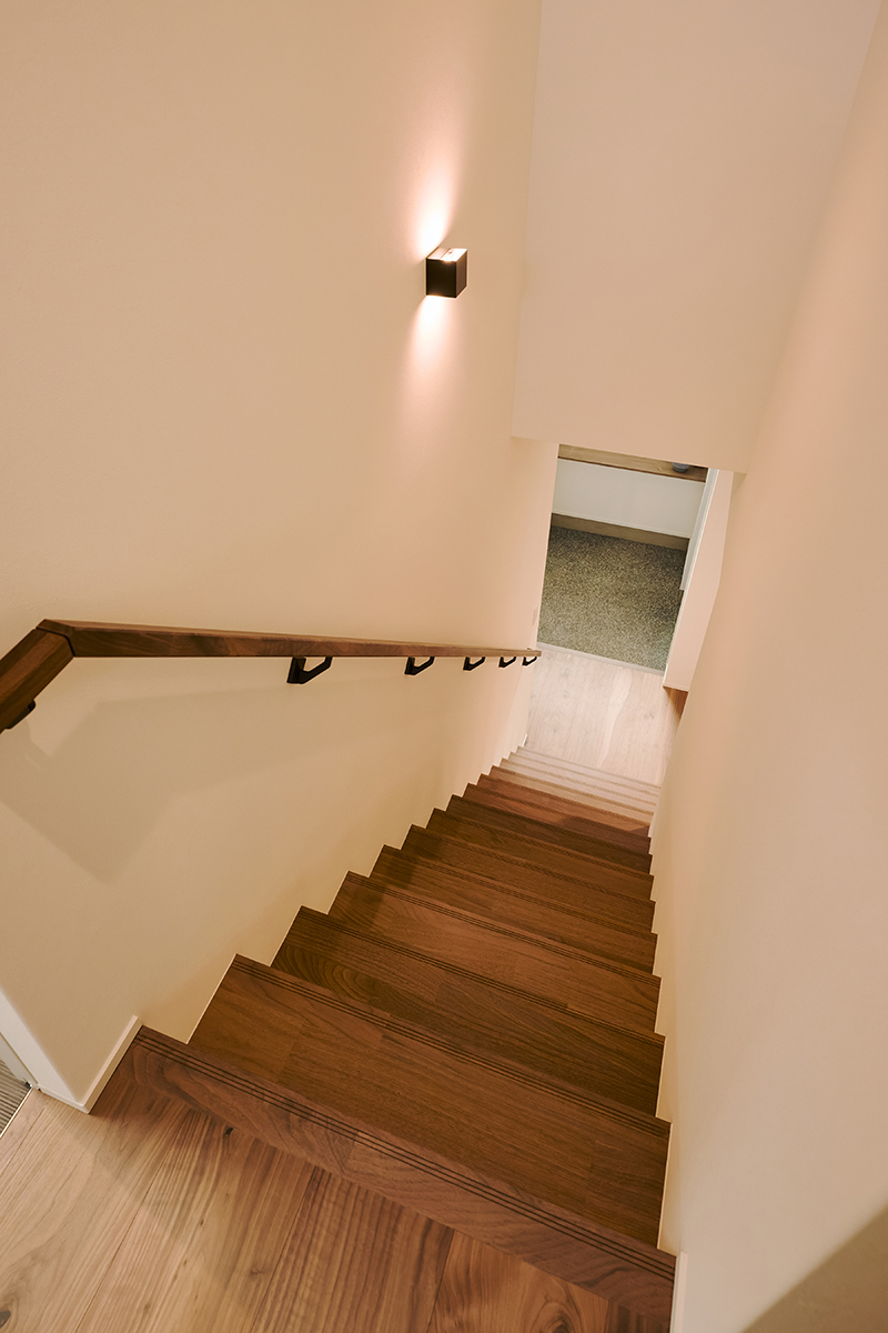 壁に広がるやわらかな灯りがやさしく照らす階段