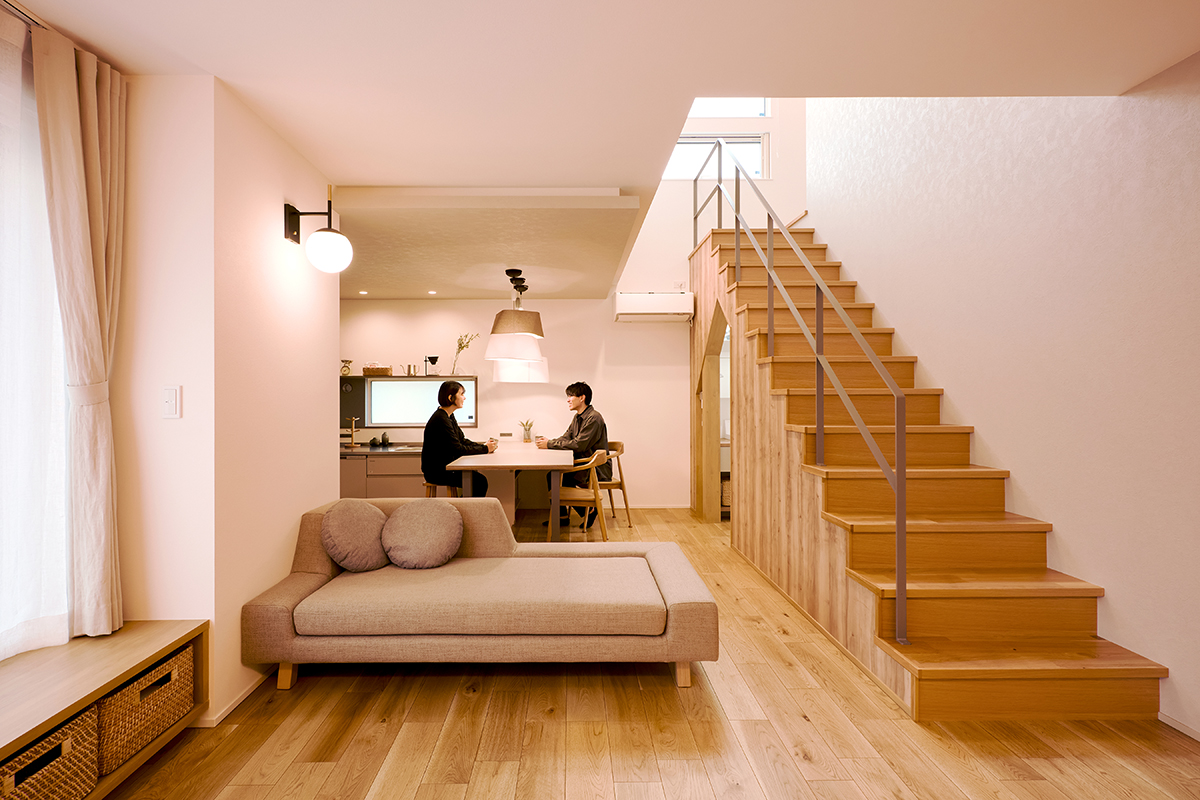 球状のブラケットライトがくつろぎ空間を優しく演出する。リビング階段の上は吹抜けになっているのでコンパクトながら開放的