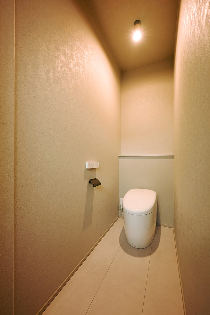 トイレは手洗器や収納を設けず、極力シンプルに。シンプルな分、ペーパーホルダーや電球のソケットに使われた黒が引き立つ